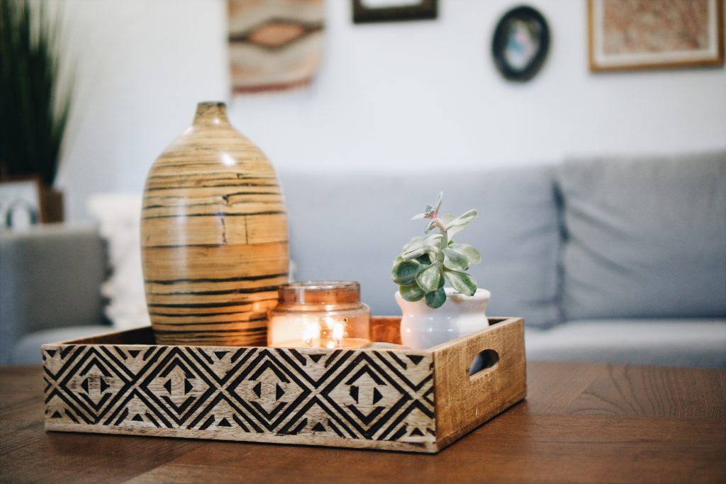 A vase, candle, and a cactus as decoration for a centre table