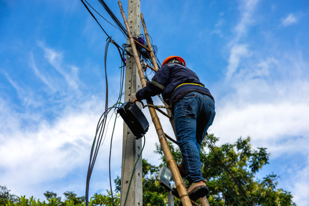 a lineman up a cable pole